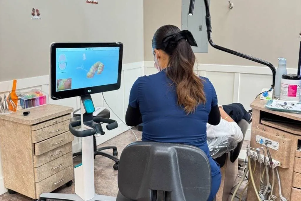 Dental professional using digital technology to demonstrate clear aligners treatment options in an orthodontic office.